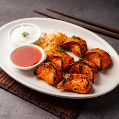 Tandoori momo, veg or non veg in red and cream sauce, served with sauce. Nepal and Tibet recipe
